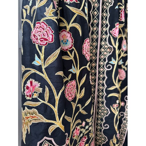 1069 - An Indian embroidered long length silk jacket on black background with split sides richly hand worke... 