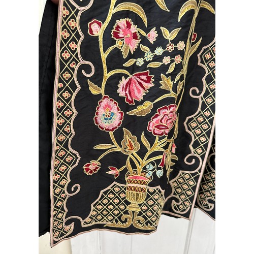 1069 - An Indian embroidered long length silk jacket on black background with split sides richly hand worke... 