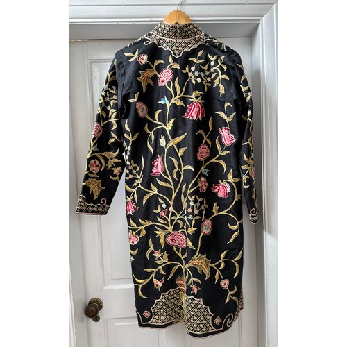 1069 - An Indian embroidered long length silk jacket on black background with split sides richly hand worke... 