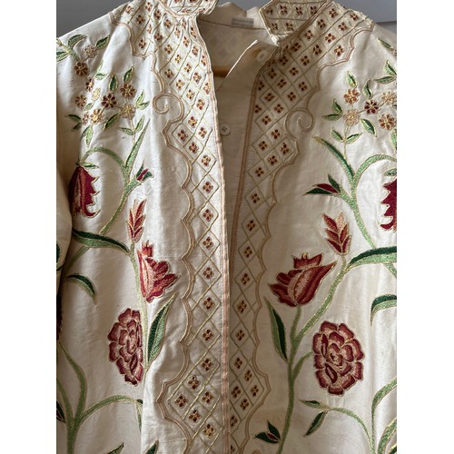 1070 - A good quality Indian embroidered long length silk jacket on cream background with split sides richl... 