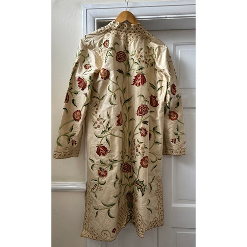 1070 - A good quality Indian embroidered long length silk jacket on cream background with split sides richl... 