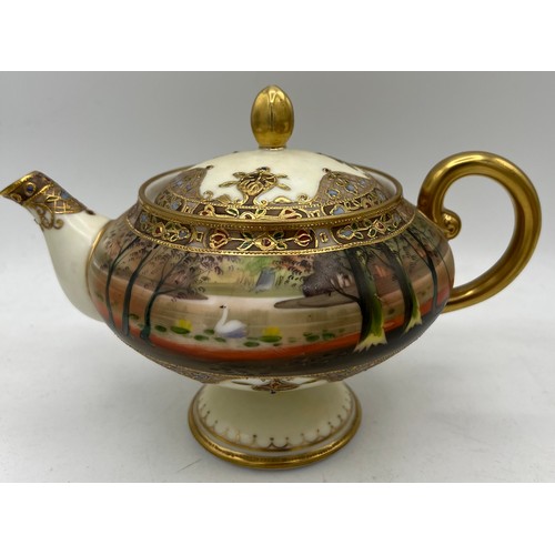 298 - A Nippon hand painted moriage teapot and lidded sucrier.