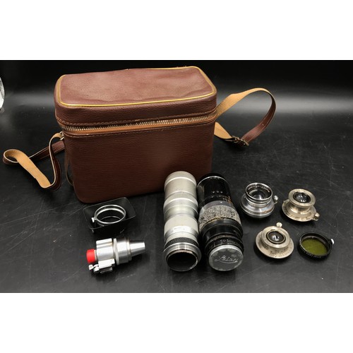 869 - A leather camera case containing a collection of Leica lenses to include a 1936 Summar 5cm f-2 No.30... 