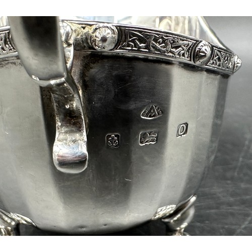 851 - A silver jug on three legs with faceted body and dragon embellishment to legs and handle hallmarked ... 