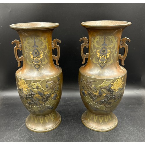 1010 - A pair of heavy decretive twin handled bronze vases relief cast in brass and other metals with birds... 