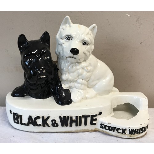 319 - A ceramic model of two dogs with the words 'Black & White Scotck Whisky' printed.