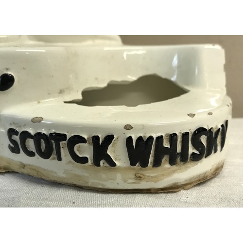 319 - A ceramic model of two dogs with the words 'Black & White Scotck Whisky' printed.