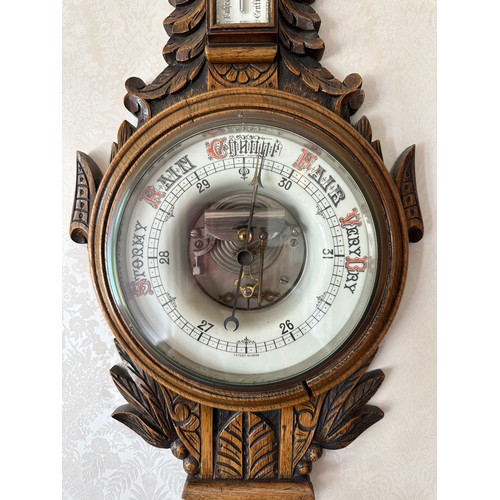 1033 - An Edwardian carved oak aneroid barometer. 93 h x 30cm w.