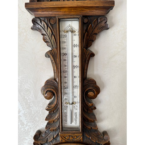 1033 - An Edwardian carved oak aneroid barometer. 93 h x 30cm w.