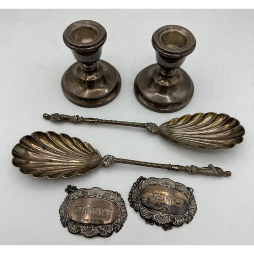 380 - Two silver decanter labels for Sherry and Whisky, two apostle spoons and a pair of weighted candlest... 