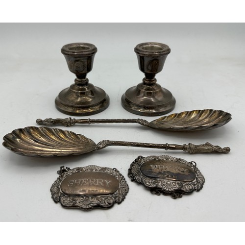 380 - Two silver decanter labels for Sherry and Whisky, two apostle spoons and a pair of weighted candlest... 