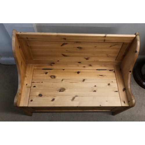 138 - A pine settle with a hinged seat storage space 100w x 85h x 51dn cm.