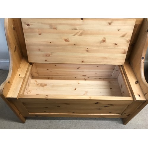 138 - A pine settle with a hinged seat storage space 100w x 85h x 51dn cm.