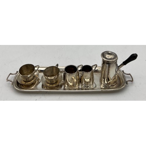 861 - A miniature silver coffee service on tray, comprising coffee pot, two cups and saucers, milk and sug... 