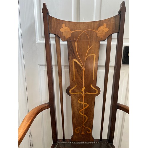 139 - A mahogany and inlaid Art Nouveau open armchair with leather seat. Height to back 115cm.