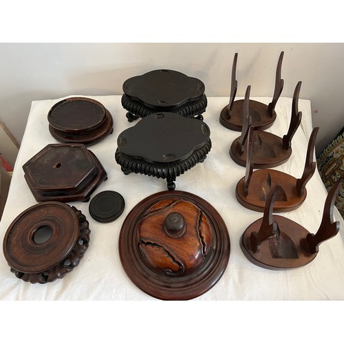 1233 - A quantity of oriental hardwood stands and a lid. (11)