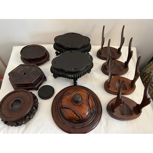 1233 - A quantity of oriental hardwood stands and a lid. (11)