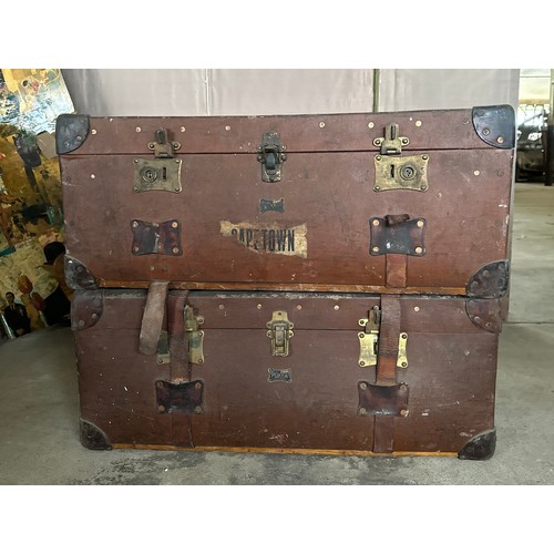 1237 - Two early 20thC travelling trunks with leather handles, corners and straps to one. Some luggage labe... 