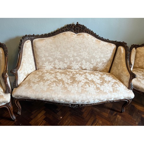 153 - A French cream upholstered sofa and two matching armchairs with decorative wood surround. Sofa 140 w... 