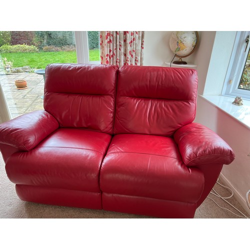 155 - A pair of red leather electric two seater sofas.