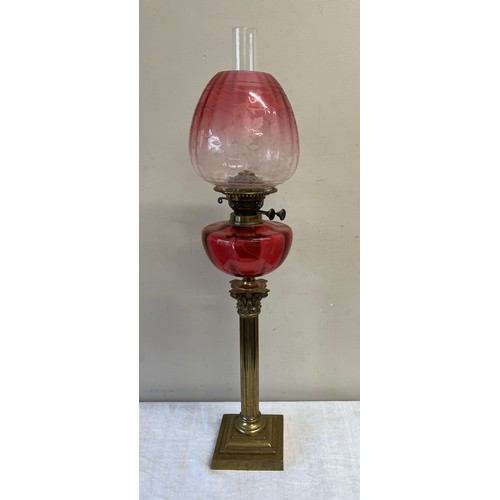 762 - A 19thC oil lamp with brass Corinthian column base and cranberry bowl with etched cranberry glass sh... 