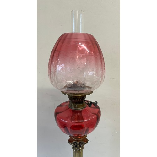 762 - A 19thC oil lamp with brass Corinthian column base and cranberry bowl with etched cranberry glass sh... 