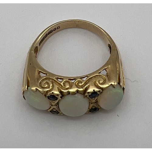 478 - A 9 carat gold ring set with three opals and four sapphires. Size N. Weight 4.2gm.