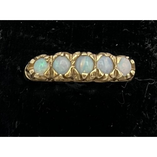 479 - A 9 carat gold ring set with five opals. Size N. Weight 2.2gm.