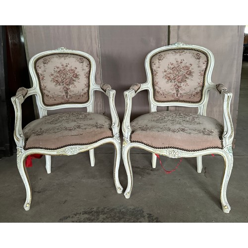 167 - A pair of white painted upholstered open armchairs in the French style.