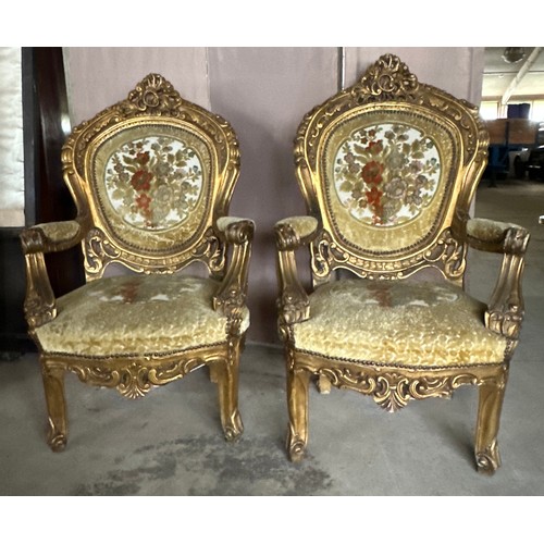 170 - A pair of ornately carved gilt upholstered open armchairs. 118cm h x 70 w x 63 d.