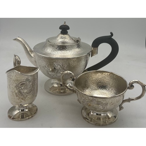 864 - A three piece silver tea set with ebony knop and handle. Birmingham 1908, maker T.H. Hazel wood and ... 