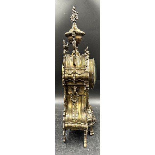 1043 - A large ornate brass mantle clock with white enamel face. 49cm h.