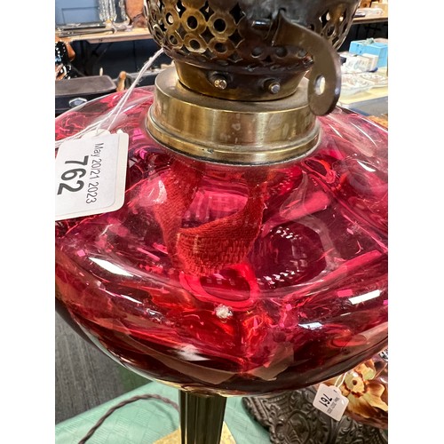 762 - A 19thC oil lamp with brass Corinthian column base and cranberry bowl with etched cranberry glass sh... 