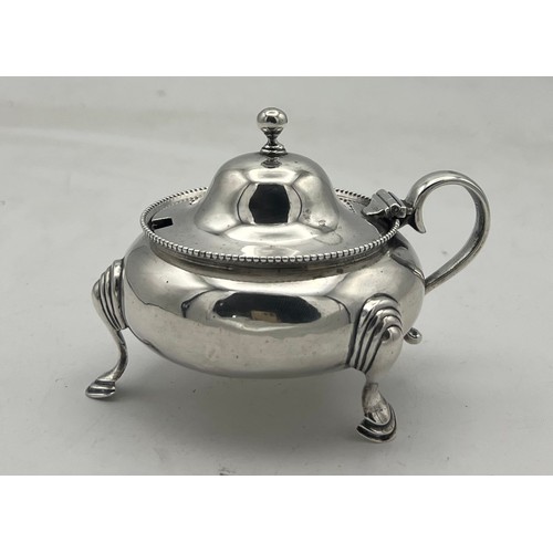 61 - A cauldron shaped silver mustard pot on three hoof feet, the domed cover rising to a ball knop. Lond... 