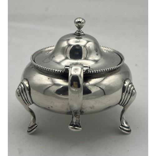 61 - A cauldron shaped silver mustard pot on three hoof feet, the domed cover rising to a ball knop. Lond... 