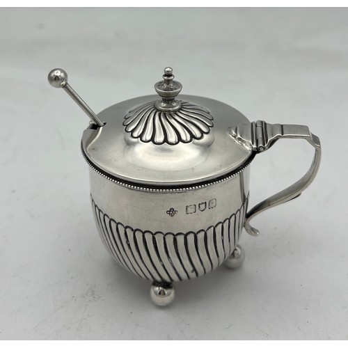 65 - A simple “set-pot” shaped silver mustard pot with clear glass liner on four ball feet. The lower hal... 