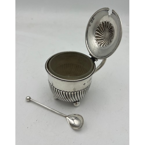 65 - A simple “set-pot” shaped silver mustard pot with clear glass liner on four ball feet. The lower hal... 