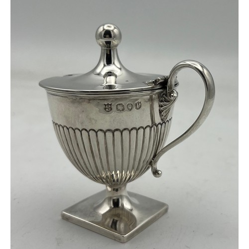 66 - An urn shaped silver mustard pot on a square base, the lower half of the body fluted, the lid rising... 