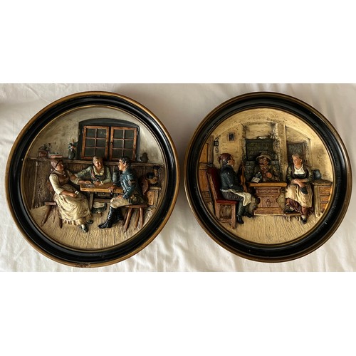 75 - A pair of Musterscutz relief moulded wall plaques depicting tavern scenes. 33cm d.