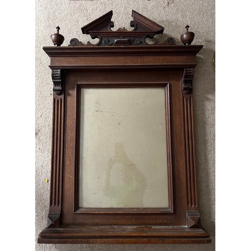 82 - A nineteenth century decorative oak frame with carved cornice between two finials. Total size 94 x 6... 