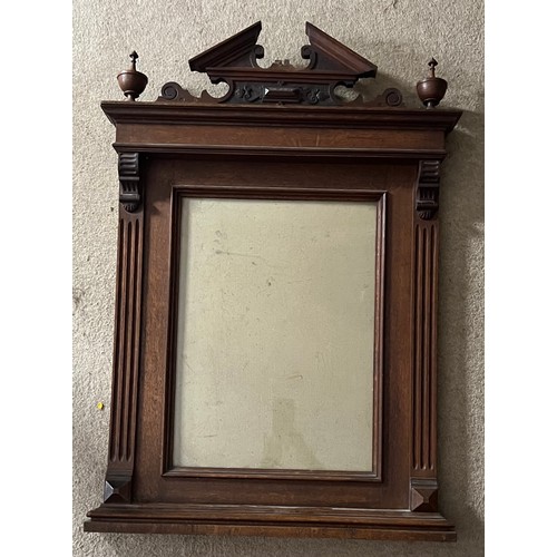 82 - A nineteenth century decorative oak frame with carved cornice between two finials. Total size 94 x 6... 