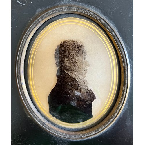 1306 - Silhouette of a gentleman in profile painted on convex glass with a verre églomisé border, marked to... 