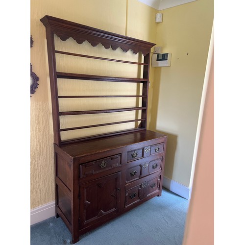 51 - An 18thC oak dresser comprising four drawers and one cupboard with rack to back. 125cm w x 45d x 190... 