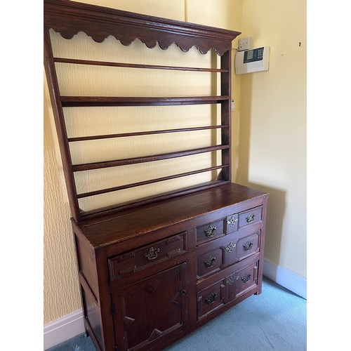 51 - An 18thC oak dresser comprising four drawers and one cupboard with rack to back. 125cm w x 45d x 190... 