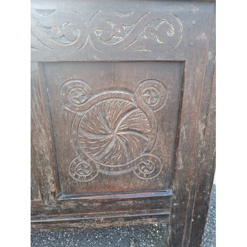 58 - An 18thC oak panelled kist with carving to front. 72h x 130w x 58d.