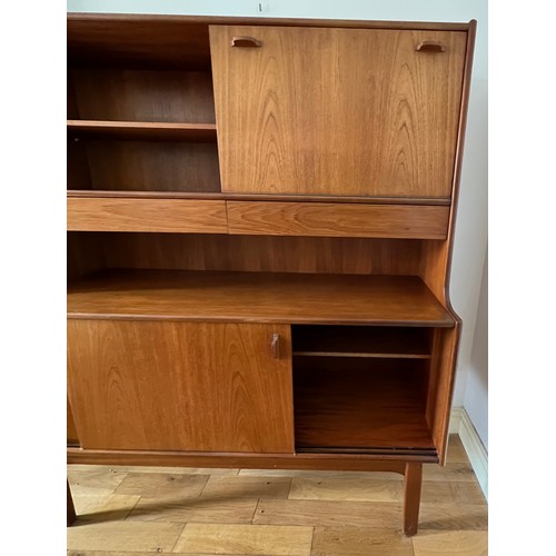 60 - A mid 20thC teak unit comprising two cupboards, two drawers and a drinks cabinet. 122cm w x 44cm d x... 