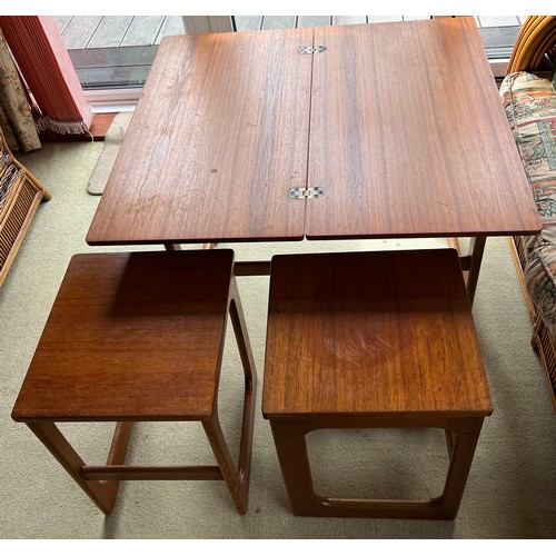 66 - A mid 20thC McIntosh teak nest of three tables. The largest of which turns and opens to 74cm x 81cm ... 