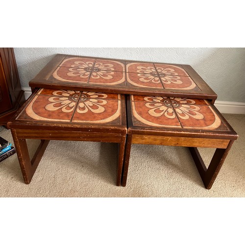 68 - A nest of three mid 20thC tile topped tables. Largest 96cm x 48cm x 40cm h.