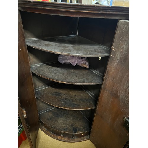 69 - A Georgian mahogany two door corner cupboard with shelves and three small drawers to the interior. 1... 