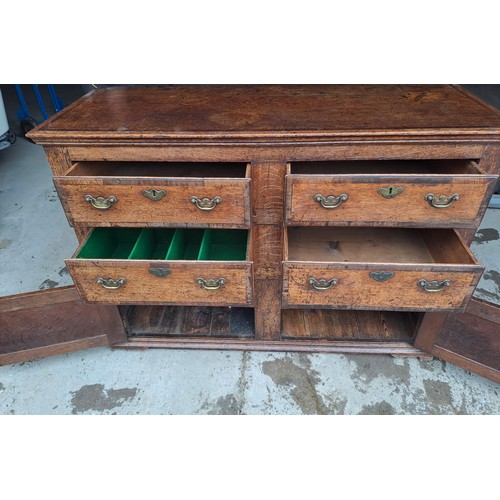 74 - A Georgian oak dresser base with cross banding to drawers and brass handles. 135cm w 52cms d x 93cm ... 